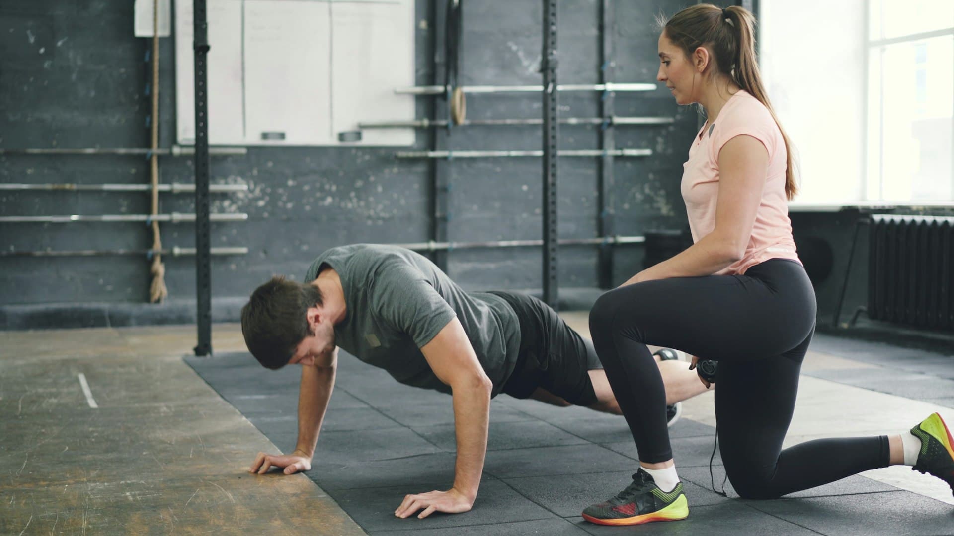 A trainer spotting a member during a strength exercise