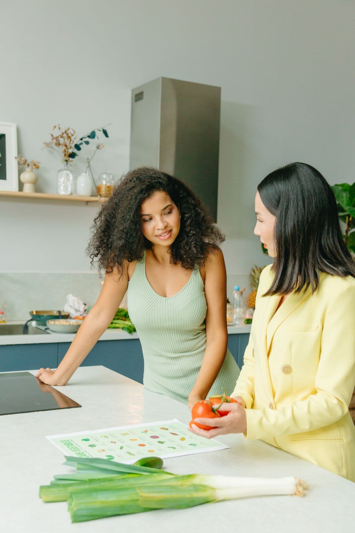 Nutrition coach advising a member over fresh vegetables and a healthy eating chart