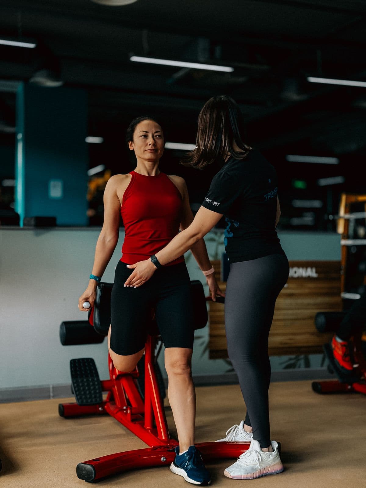 Trainer correcting a member's form during a one-to-one gym session
